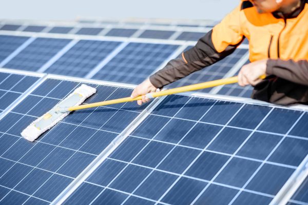 Mann putzt Solaranlage